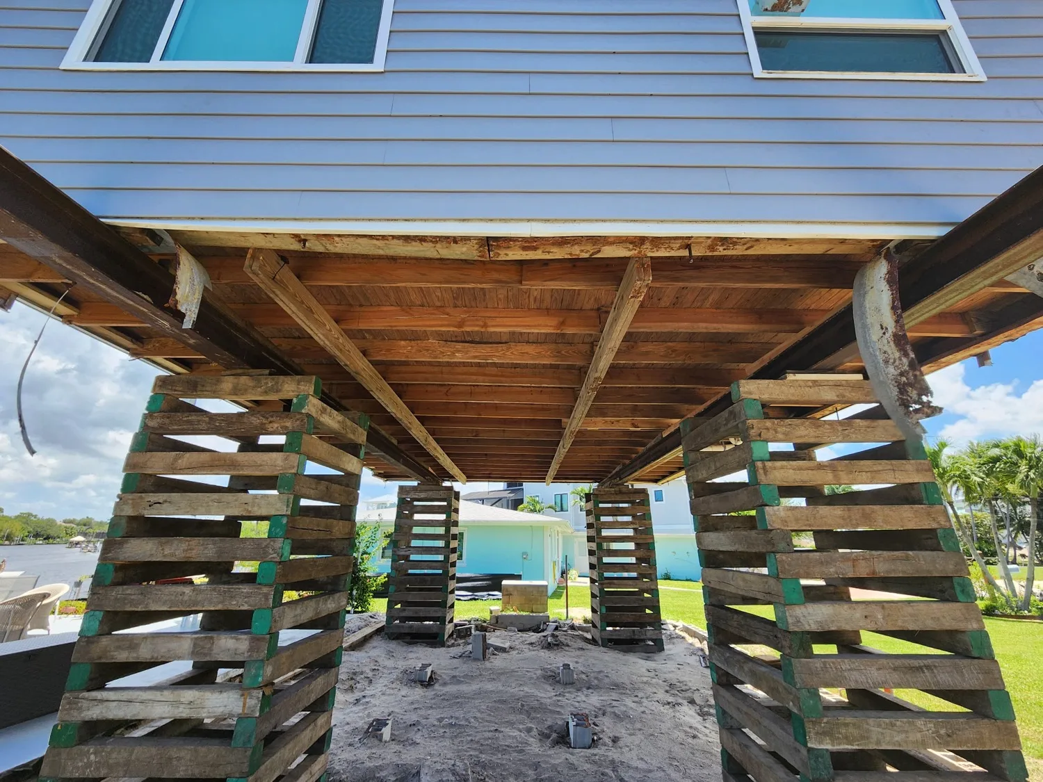 Home raised on temporary cribbing during a structural elevation; location and completion not verified